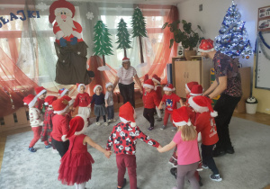 Motylki tańczą w kółeczku wspólnie z Ciocią Ewą i Panem Darkiem.