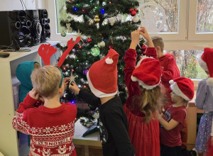 Dzieci ubierają choinkę.