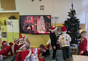 Chłopcy ubierają ważkową choinkę.