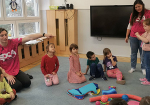 Instruktor pływania wyjaśnia jak prawidłowo zakładać pas pływacki.