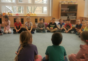 Instruktor pływania rozmawia z dziećmi na temat bezpieczeństwa w wodzie i nad morzem.