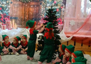 Elfiki dekorują choinkę kolorowymi ozdobami.