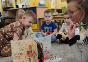 Pani Agata czyta dzieciom bajkę o małych elfikach.