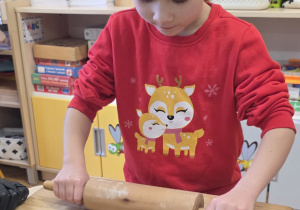 Dziewczynka wałkuje ciasto na pierniki.