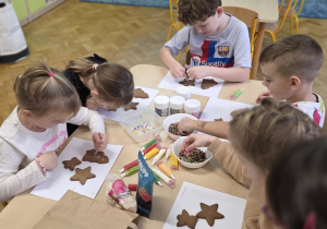 Dzieci dekorują pierniczki wg własnego pomysłu.