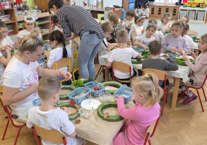 Dzieci wykonują stroiki świąteczne z dostępnych materiałów.