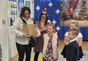 Dzieci oraz Pani dyrektor przyjmują upominek za udział w festiwalu.