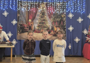 Dzieci śpiewają świąteczną piosenkę na festiwalu kolęd.