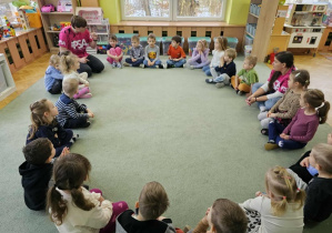 Instruktor pływania rozmawia z dziećmi na temat bezpieczeństwa w wodzie i nad morzem.