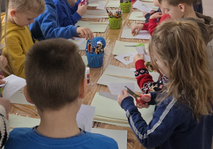 Dzieci wykonują pracę plastyczną - karmnik.