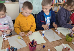 Dzieci wykonują pracę plastyczną z dostępnych materiałów.