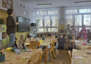 Dzieci uważnie słuchają Pani Kasi, która tłumaczy, co będzie zadaniem dzieci na dzisiejszych warsztatach.