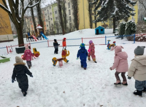Dzieci biegają po śniegu.