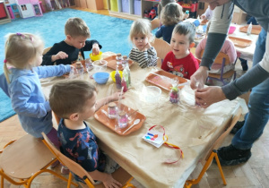Dzieci czekają na zapakowanie gotowych dyfuzorów, przywiązanie wizytówki okolicznościowej.
