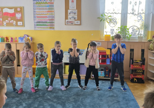 Dzieci ćwiczą pozycję drzewa.