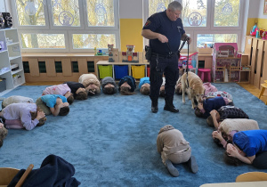 Koka sprawdza, czy dzieci prawidłowo wykonały pozycję żółwia.