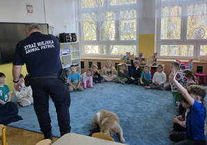 Funkcjonariusz sekcji Animal Patrol rozmawia z dziećmi na temat kontaktów z nieznajomymi i dzikimi zwierzętami.