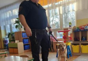 Funkcjonariusz Animal Patrolu wraz ze swoim psem - biszkoptową labradorką.