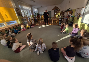 Funkcjonariusz Straży Miejskiej rozmawia z dziećmi na temat spotkania z nieznajomymi i niebezpiecznymi zwierzętami.