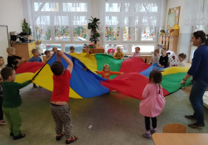 Dzieci bawią się z chustą animacyjną.