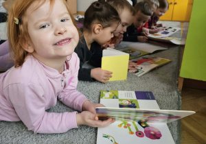 Dziewczynka uśmiecha się do zdjęcia.