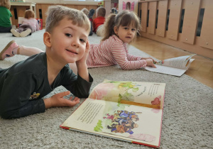 Chłopiec oglądaja książkę.