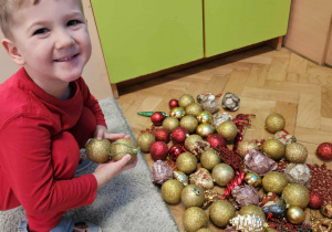 Chłopiec wybiera bombkę do zawieszenia.