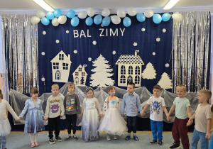 Dzieci trzymają się za ręce i czekają na rozpoczęcie zimowej zabawy.