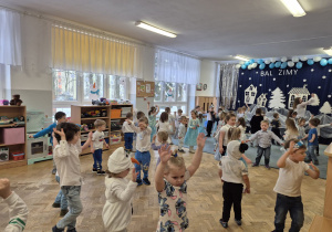 Dzieci tańczą wspólnie przy zimowej piosence.