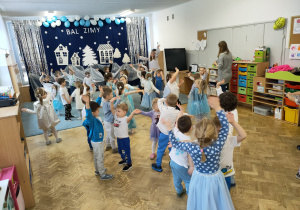 Dzieci tańczą wspólnie przy zimowej piosence.