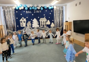 Motylki trzymają się za ręce i tańczą wspólnie przy zimowej piosence.