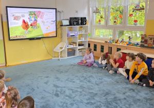 Dzieci oglądają film edukacyjny "Skąd się biorą produkty ekologiczne".