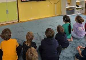Dzieci oglądają film edukacyjny nt. etapów powstawania pieczywa.
