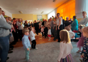 Dzieci stają w kole wewnątrz, seniorzy tworzą koło na zewnątrz. Wszyscy gotowi do wspólnej zabawy tanecznej.