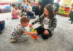 Uczennica bawi się z chłopcem mini garażem.