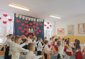 Dzieci tańczą z chusteczkami i śpiewają piosenkę.