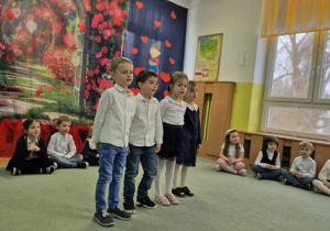 Dzieci stoją przed widownią i recytują wiersze.