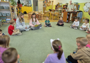 Starsze koleżanki czytają dzieciom bajki.