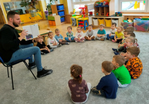 Tata pokazuje dzieciom ilustracje w książce, rozmawia z dziećmi na temat wysłuchanego opowiadania.