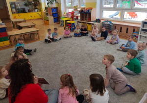 Gość prezentuje dzieciom ilustracje w książeczce.