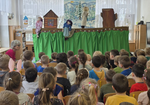 Dzieci oglądają spektakl kukiełkowy.