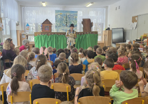 Aktorka rozmawia z dziećmi na temat zachowania w teatrze i lalek, które są wykorzystywane podczas przedstawienia.