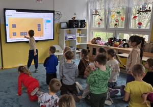 Chłopiec próbuje odnaleźć parę w grze memory na tablicy multimedialnej.