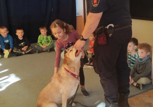 Dziewczynka głaska psa.