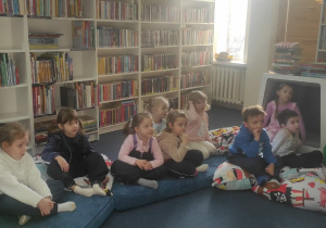 Dzieci słuchają uważnie, o czym mówi Pani bibliotekarka.