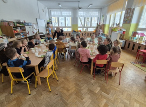 Wszystkie dzieci siedzą i jedzą śniadanie.