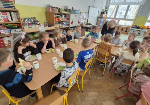 Ciocia Ania nakłada po kolei każdemu dziecku to na co ma ochotę.