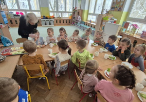 Dzieci siedzą i czekają na swoją kolei.