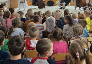 Dzieci siedzą na widowni i słuchają przepięknego koncertu pt. „Szepty starych drzew”.