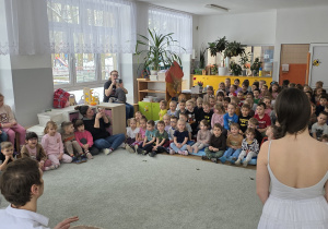 Dzieci siedzą na widowni i słuchają przepięknego koncertu pt. „Szepty starych drzew”.